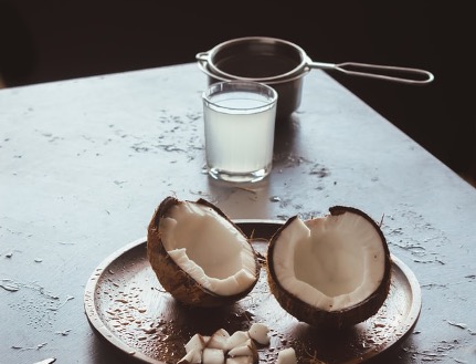 <img src="coconut.jpeg" alt="broken coconut on table with oil in cup">