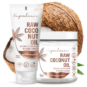 Two Kapuluan Cold-Pressed Raw Coconut Oil products for skin and hair are beautifully displayed—one in a tube, the other in a jar. Both are organic and extra virgin, set against a backdrop of a cracked coconut and lush green leaf to highlight their purity.