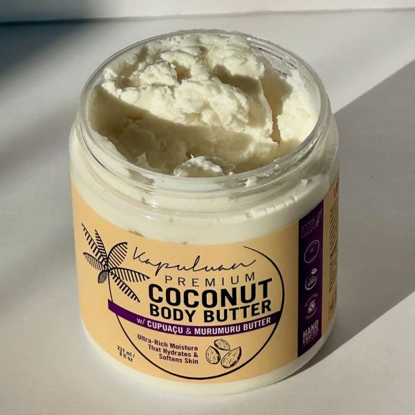 An open jar of Body Butter w/ Cupuaçu & Murumuru shows its white, fluffy texture under natural light. The label emphasizes its ultra-rich moisture properties.