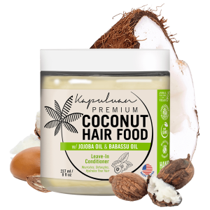 A jar of Coconut Hair Food w/ Shea and Babassu, featuring jojoba and babassu oil, sits beside half a coconut and scattered nuts. The label highlights its vegan, GMO-free, handmade attributes and an 8 fl oz volume.