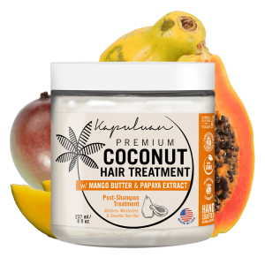 A jar of Kapuluan Coconut Hair Food with Shea and Babassu, surrounded by fresh mango, papaya, and coconut. The product promises to restore, moisturize, and smooth hair.