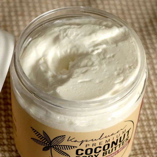 A clear jar filled with creamy coconut body butter sits on a woven surface. The label on the jar reads "Kapuluan Best Sellers Collection.