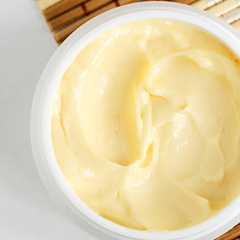 A creamy white Organic Butters Collection custard or pudding in a white bowl, showcasing a smooth and rich dessert texture.