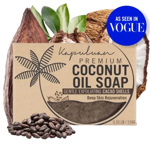 A bar of Coconut Oil Soap with Gentle Exfoliating Cacao Shells is displayed with a background of coconut, cacao beans, and leaves. The packaging highlights features like "Gentle Exfoliating Cacao Shells" and "Deep Skin Rejuvenation." A blue "As Seen in Vogue" badge is at the top right.