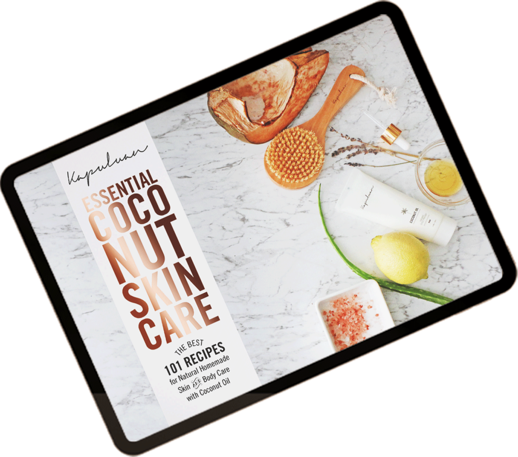 Flat lay of a digital tablet displaying a coconut skincare advertisement, surrounded by coconut and natural ingredients and beauty products on a marble surface.