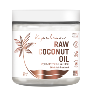Jar of kapuluan raw coconut oil, cold-pressed and natural for skin and hair treatment, labeled vegan, cruelty-free, gmo-free, and handcrafted, with a palm leaf design on the label.