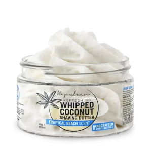A clear glass jar containing refreshing whipped coconut shaving butter with a tropical beach scent. The jar has a blue and white label, featuring a palm tree graphic and the text "handcrafted in small batches." The jar holds 4 oz (118 ml) of product.