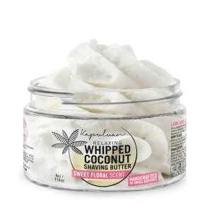 An open container of Kapuluan Relaxing Whipped Coconut Shaving Butter with sweet floral scent. The jar is filled with fluffy, creamy shaving butter. It's labeled as handcrafted in small batches, 4 oz / 118 ml. The design features a palm tree logo and product details.